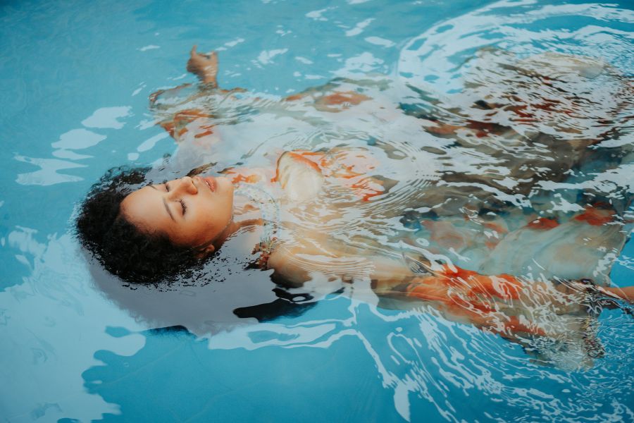 chica flotando en piscina