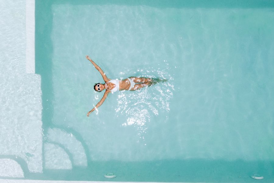 mujer flotando en el agua de una piscina grande
