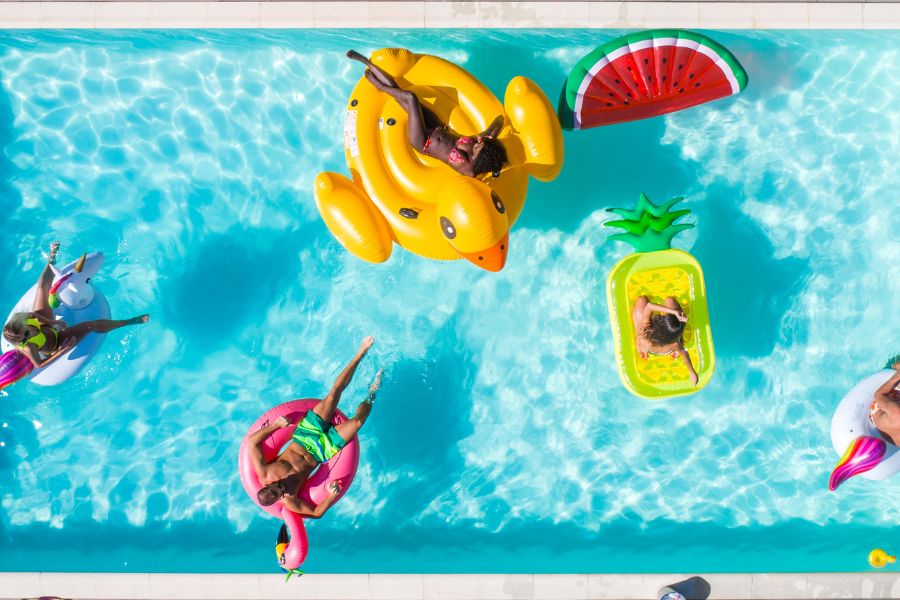 gente con flotadores bañándose en la piscina