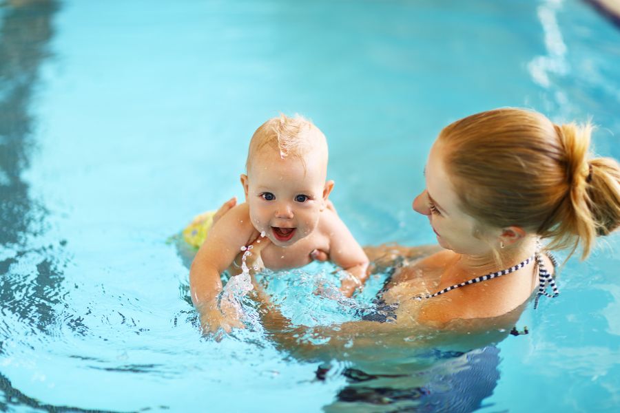 madre con su bebé en una piscina