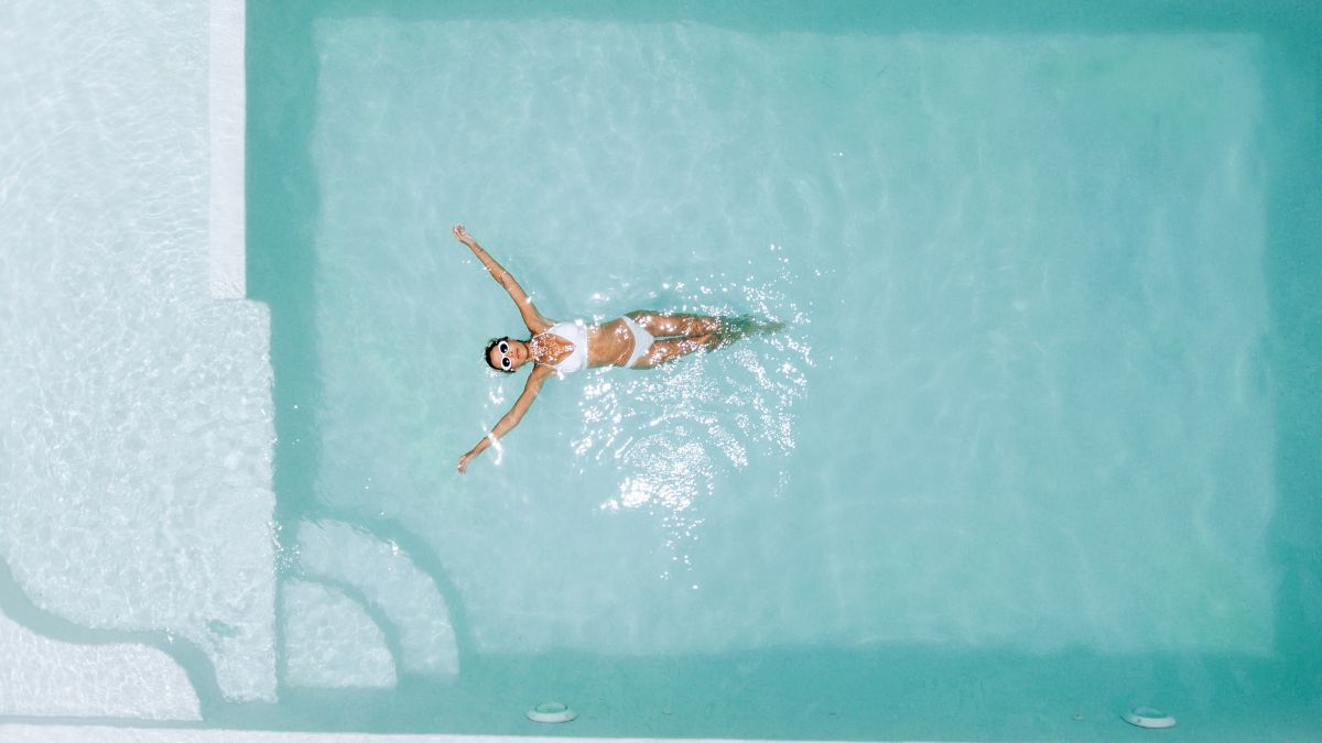 chica flotando en piscina