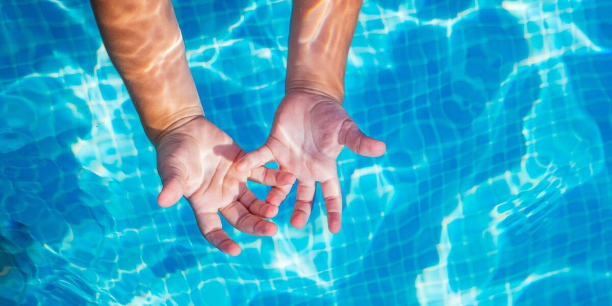 manos niño piscina